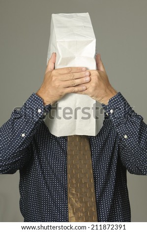 Over stressed businessman with paper bag on head