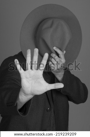 Man hiding face with hat wants to be anonymous
