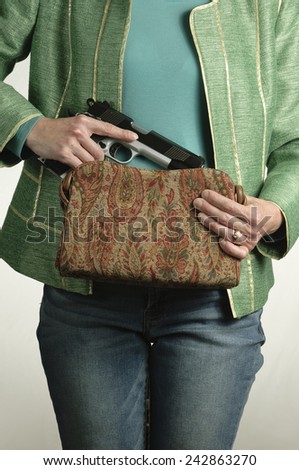 Woman pulls a large gun from her swanky purse