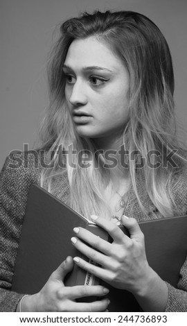Young female student with binder feels insecure