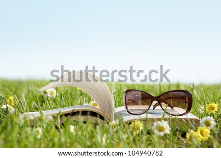 Glasses on a book outside with green grass