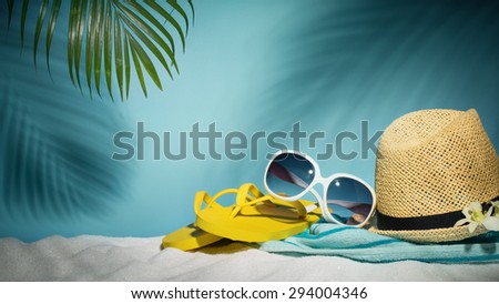 Beach accessories with sunglasses,hat,flip-flop and towel on sands