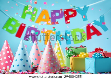 Birthday gift boxes with paper confetti on blue background