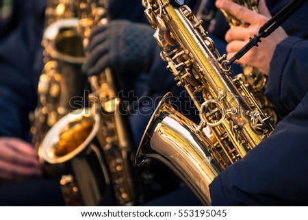 Saxophones of a town band during a performance.