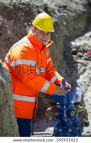 Construction worker checks a water pipe