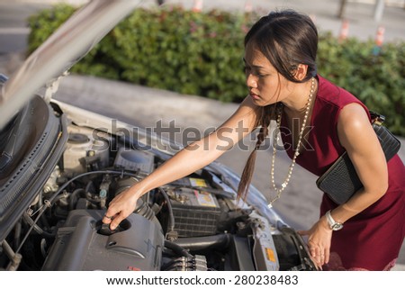 Businesswoman opened the hood broken car on the side see engines that are damaged or not. Portrait of Asia