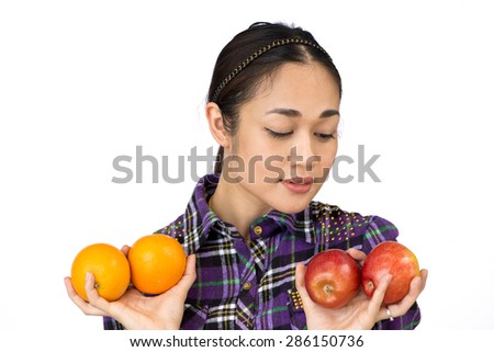 Close up of a young woman presenting fruits oranges and apples. Portrait of Asia.  Isolated