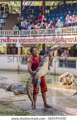 THAILAND, SAMUT PRAKAN - December 27,2015: An unidentified zoo keeper embrace crocodile as part of \
