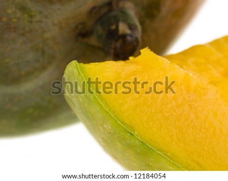 Juicy mango slice isolated against white background with whole mango - narrow dof