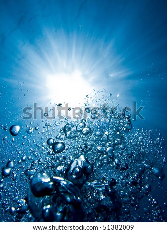 Bubbles from a scuba diver rising to the surface in a blue sea