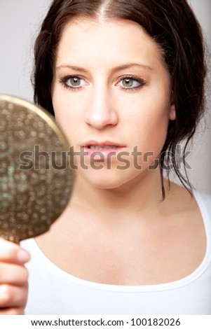 Portrait of a woman looking at herself in the mirror