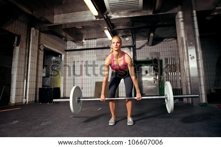 Female fitness performing doing deadlift exercise with weight bar
