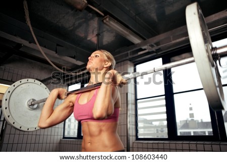 Bodybuilder doing exercise with a heavy weight bar inside gym