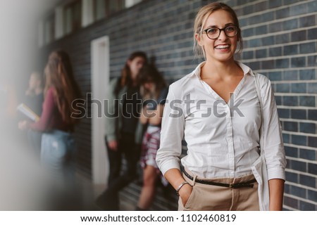 Portrait of beautiful university teacher walking in campus. Smiling young college professor in campus.