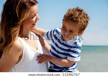 Beautiful young mom plays with her cheerful son