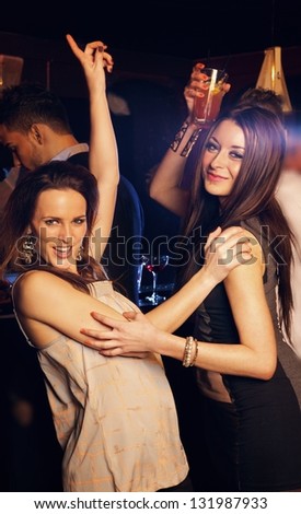 Beautiful carefree girls party hard on the dance floor