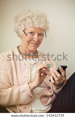 Old lady texting someone using her cell phone
