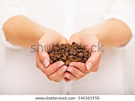 Woman with a handful of coffee beans in both hands