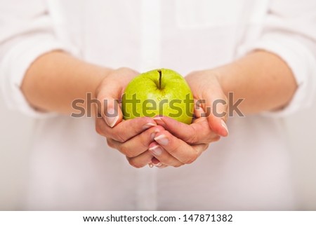 Woman with a green apple in hands