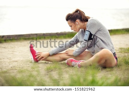 Woman In Sportswear Outdoors Stretching Her Legs Before Running