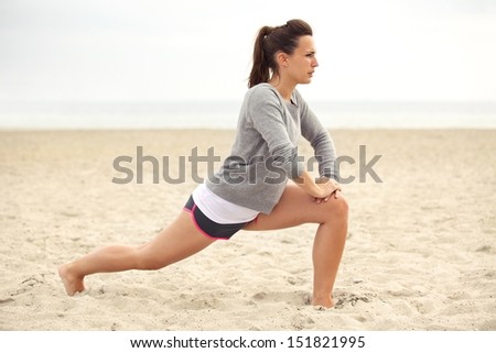 Stretching woman in outdoor exercise smiling happy doing yoga stretches after running. Beautiful happy smiling sport fitness model outside on summer day.
