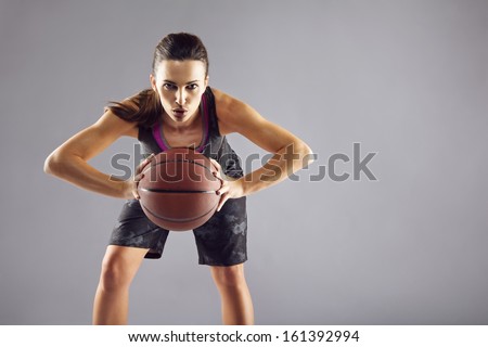 Portrait Of Young Female Basketball Player Passing The Ball. Beautiful Caucasian Woman In Sportswear Playing Basketball On Grey Background With Copyspace