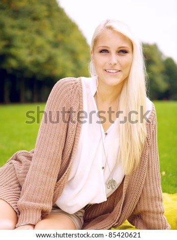 Portrait of a cute girl sitting on a blanket in a park