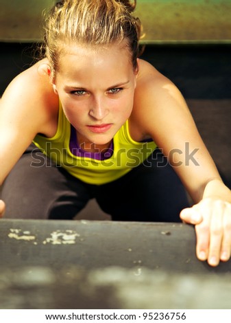Overhead view of the determined expression on the face of a young woman traceur participating in parkour.