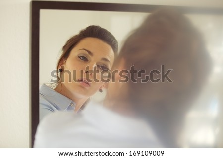 Beautiful Young Businesswoman Putting On Mascara While Looking At The Mirror. Caucasian Female Model Putting Makeup Getting Ready For Work.