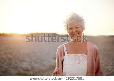 Portrait of cheerful old woman standing on the beach Smiling senior caucasian female smiling outdoors Portrait of cheerful old woman standing on the beach Smiling senior caucasian female smiling outdoors