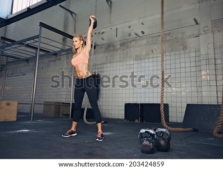 Young fitness woman lifting a heavy weight kettle bell at gym Caucasian female athlete working out at gym Fit young lady doing crossfit exercise Young fitness woman lifting a heavy weight kettle bell at gym Caucasian female athlete working out at gym Fit young lady doing crossfit exercise