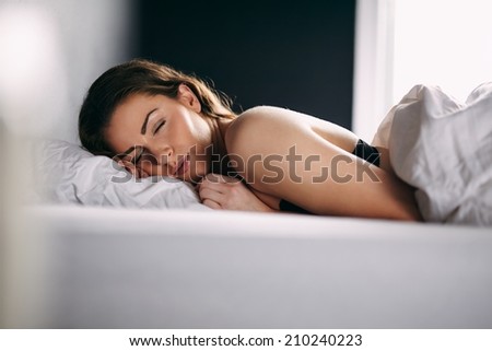 Portrait of relaxed young lady sleeping in her bed. Female model sleeping peacefully in her bed.