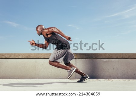Man start running on the pathway with the blue sky in the background and copy space around him. Motion blur.