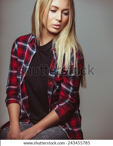 Studio shot of attractive woman looking down. Pretty young blonde looking away.