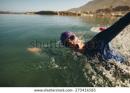 Open water swimming. Male athlete swimming in lake. Triathlon long distance swimming.