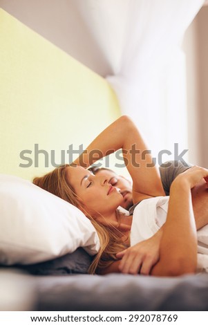 Young couple lying asleep on bed in bedroom. Woman with her boyfriend sleeping on bed together.
