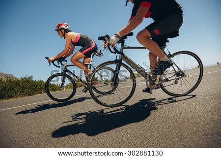 Action shot of a racing cyclists. Cyclist riding bicycles down hill on country road. Practicing for competition.