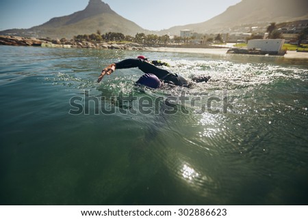 Athletes in the swim event of a triathlon competition. Triathletes swimming in open water.