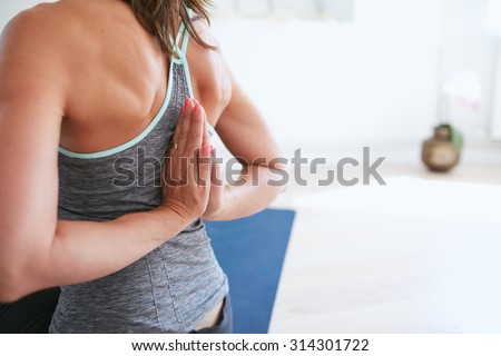 Woman doing yoga at gym, reverse prayer position. Fitness woman doing Pashchima Namaskarasana yoga.