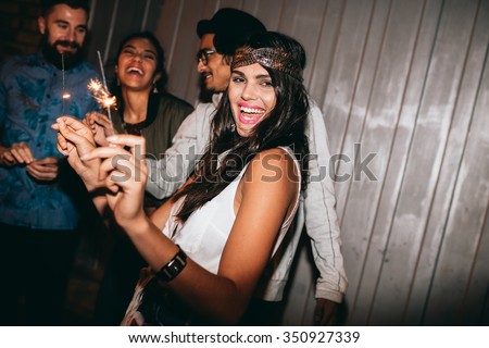 Shot of a young woman playing with sparklers at night. Best friends celebrating 4th of july outdoors.