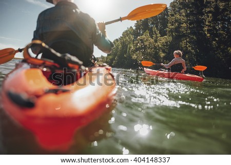 Portrait of mature woman kayaking in lake on a sunny day. Couple canoeing in a lake on  summer day.