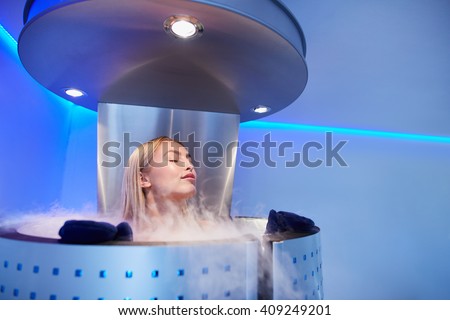 Portrait of young woman in a whole body cryo sauna. Female getting cryo therapy at the cosmetology clinic.