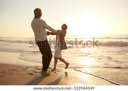 Full length shot of romantic senior couple enjoying a day at the beach. Mature couple enjoying their vacation on the beach.