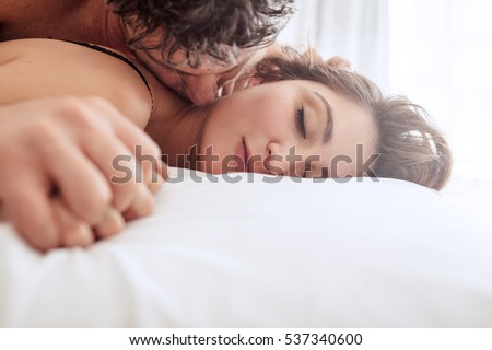Romantic young couple in bed. Man and woman in bed making love.