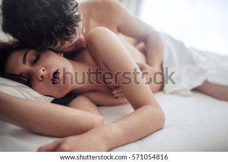 Sensual lovers in bed having passionate sex. Young man and woman making love in bedroom.