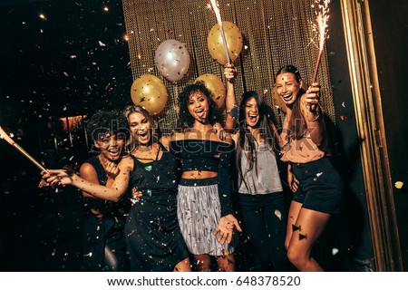 Shot of group of girls in the nightclub having a great time. Group of female friends partying in pub.