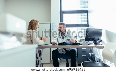 Medical specialist discussing with female patient in his clinic. Doctor with patient during consultation in medical office.