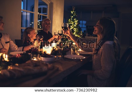 Happy family toasting wine glasses at dining table in the house. Family at dining table for christmas dinner in the house.
