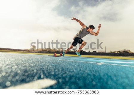 Runner using starting block to start his run on running track. Athlete starting his sprint on an all-weather running track with the help of starting block.