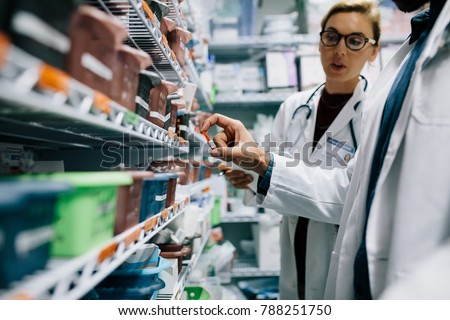Two pharmacists checking inventory at hospital pharmacy. Hospital staff stocktaking in drugstore.